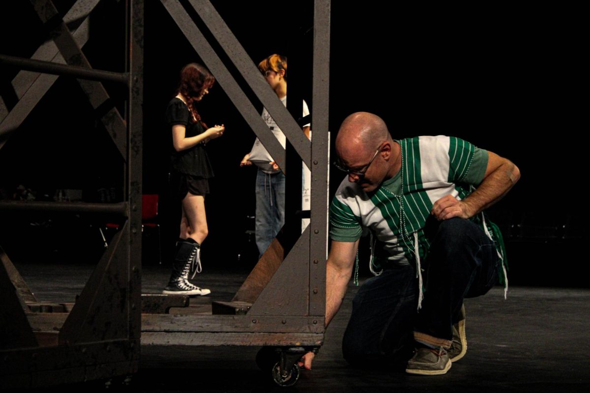 Sibbitt spiking the auditorium stage to mark where the crew should move platforms to during rehearsal for Benson's fall play, Eurydice. Photo by Hserblut Soe.