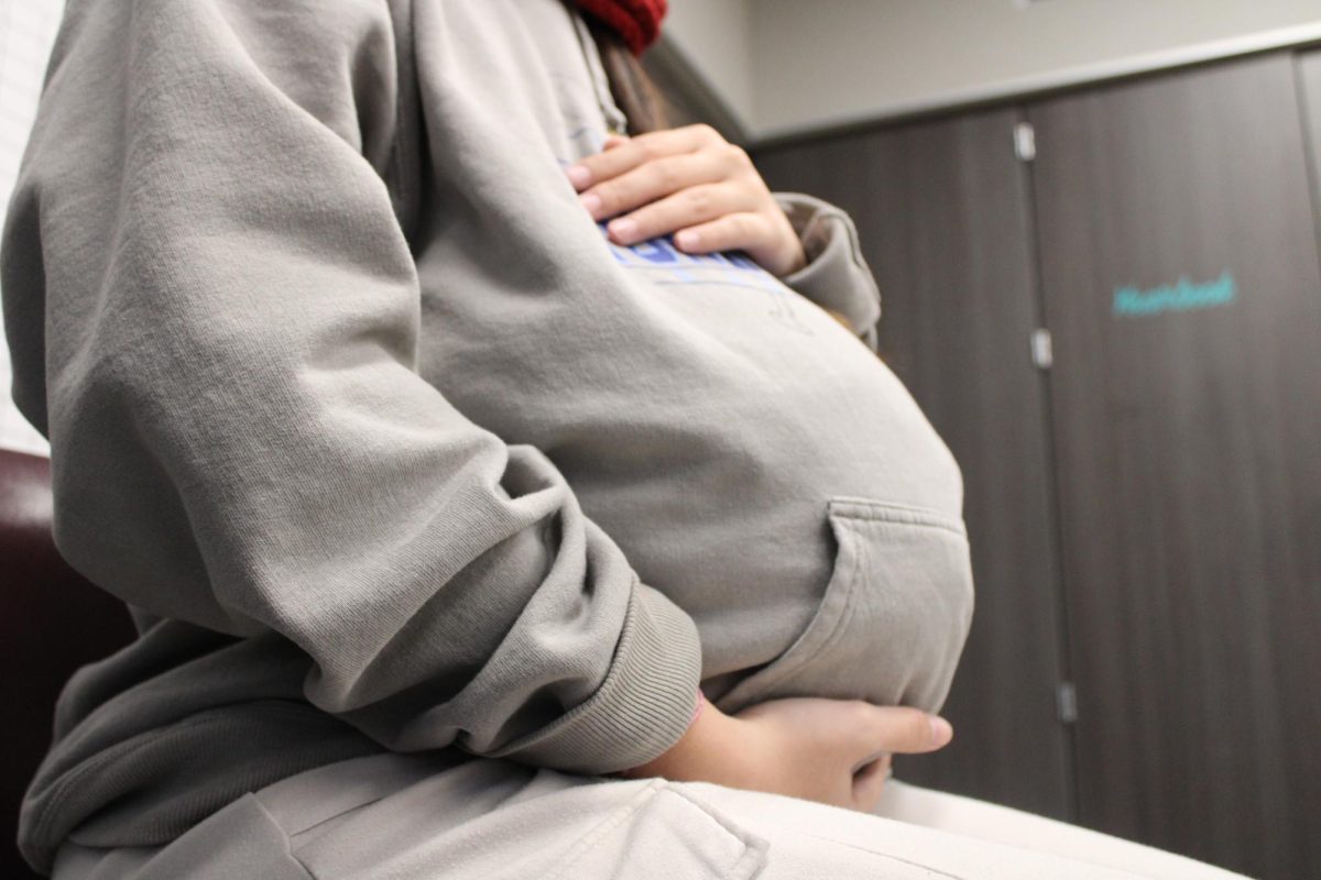 Photo illustration showing a pregnant teen sitting down.