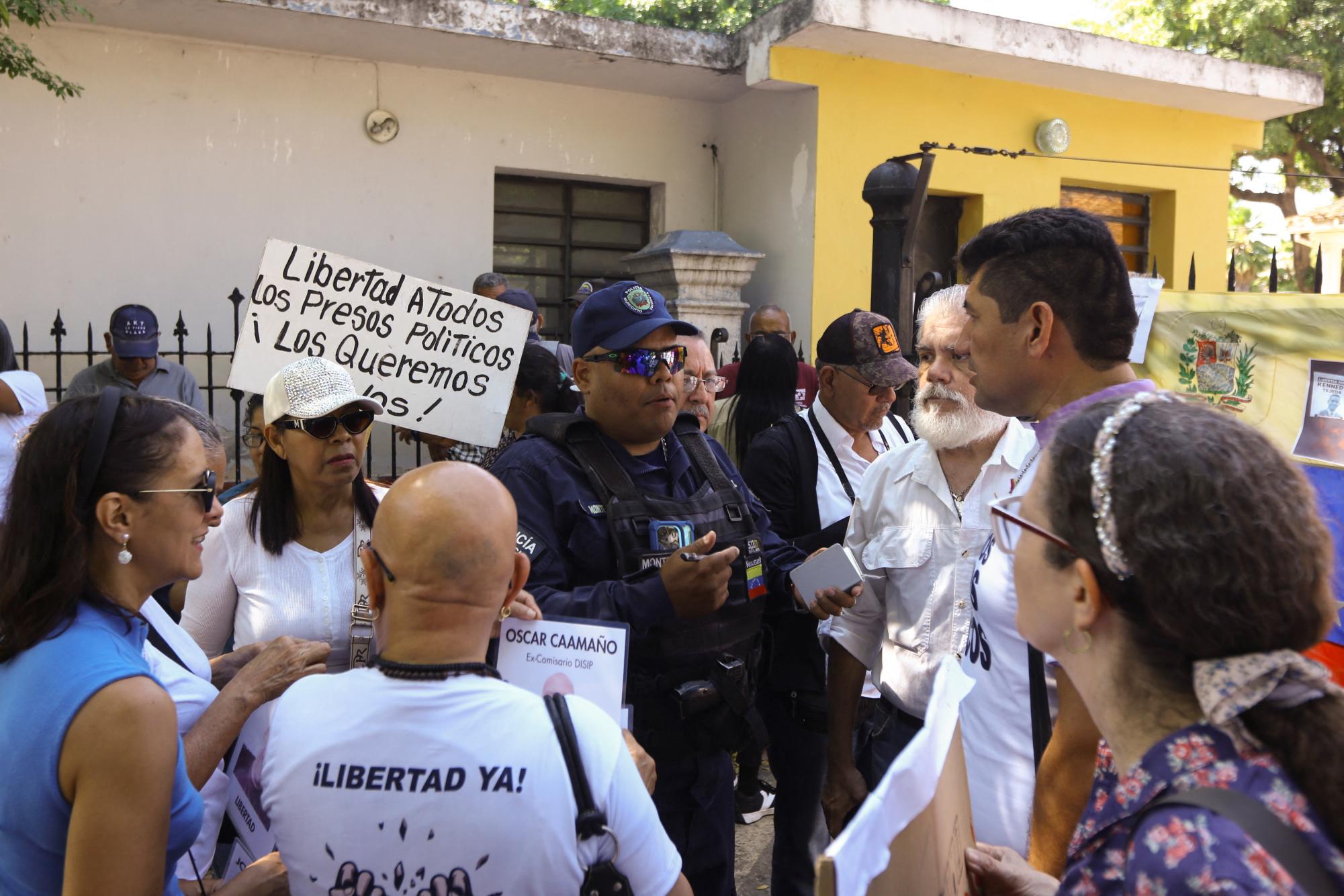 A police officer speaks with relatives of political prisoners during a protest supported by university students and calling for their release outside the rector’s office at the University of Carabobo, amid prisoner releases by the Venezuelan government following the U.S. capture of Nicolas Maduro, in Valencia, Venezuela, January 23, 2026. REUTERS/Juan Carlos Hernandez