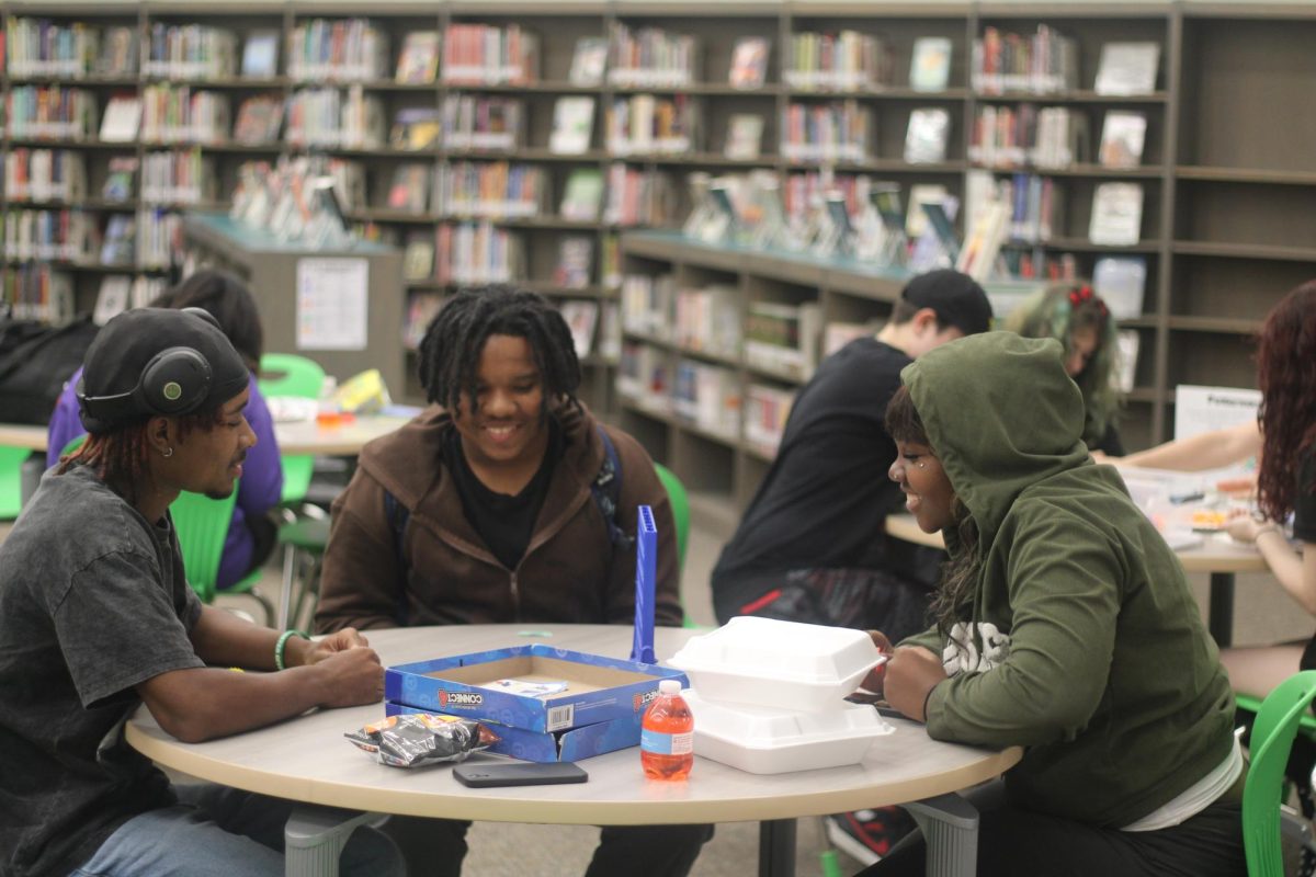 Senior Shai Bullion, Ja’Nala Mayo-David and junior Avant Vaughn play a game of UNO during Nerdcon.